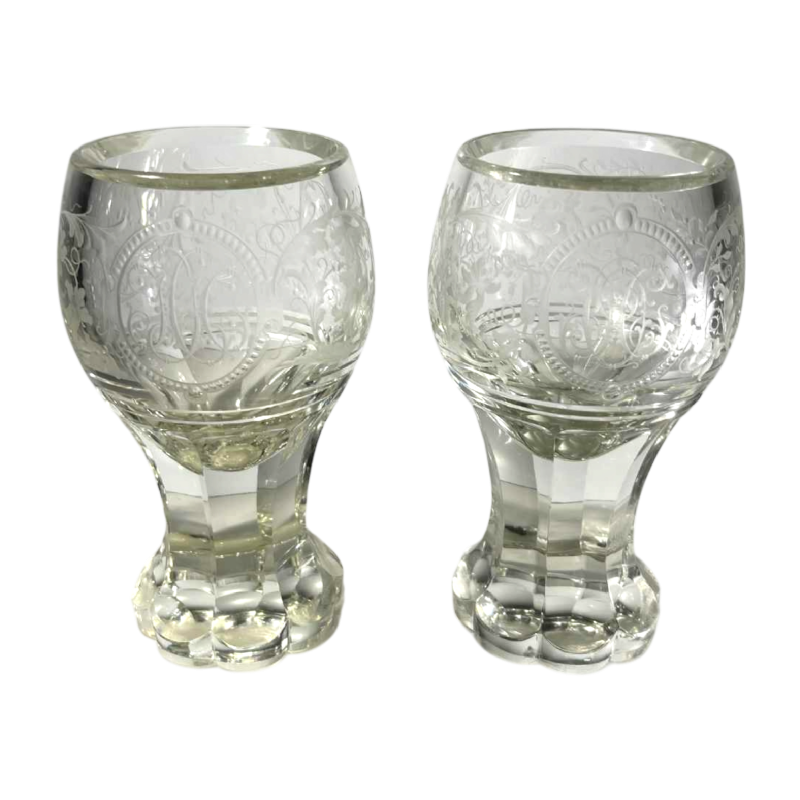 Paar glazen met steel van dik geslepen kristal met krulwerk en monogramversiering, Bohemen ca. 1900