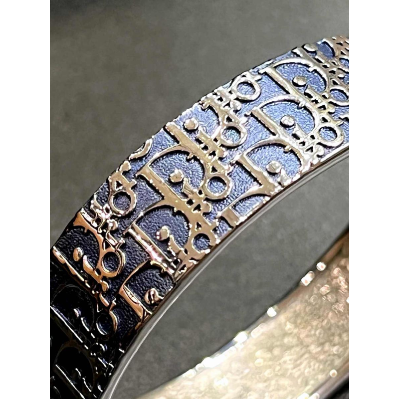 Christian DIOR, bracelet with silvered logo on bluish-grey background