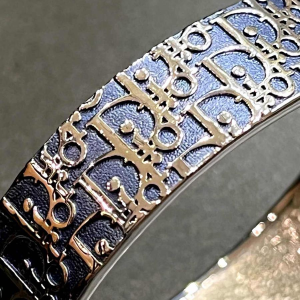 Christian DIOR, armband met zilveren logo op blauw-grijze achtergrond