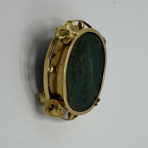 Broche in 18 karaat geel goud bezet met een bronzen Oudgriekse munt