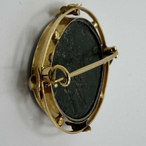 Broche in 18 karaat geel goud bezet met een bronzen Oudgriekse munt