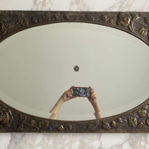 Oval Art Nouveau mirror in repoussé brass with floral decoration, early 20th c