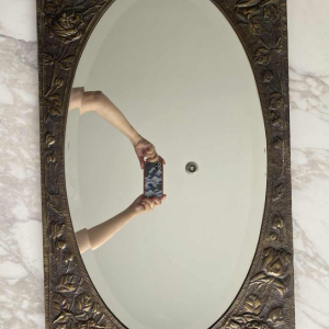 Oval Art Nouveau mirror in repoussé brass with floral decoration, early 20th c