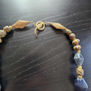 Necklace of very old glass beads, including a central JATIM or PELANGI bead in 4 colours