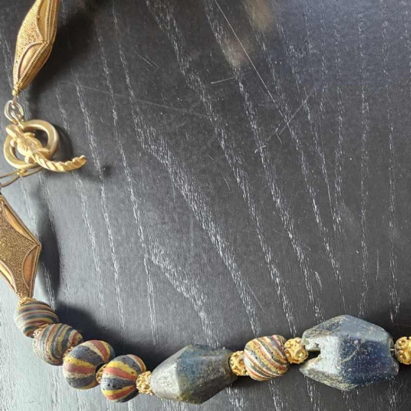 Necklace of very old glass beads, including a central JATIM or PELANGI bead in 4 colours