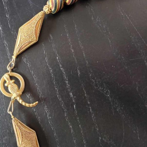 Ketting van zeer oude glazen kralen, waaronder een centrale JATIM of PELANGI kraal in 4 kleuren