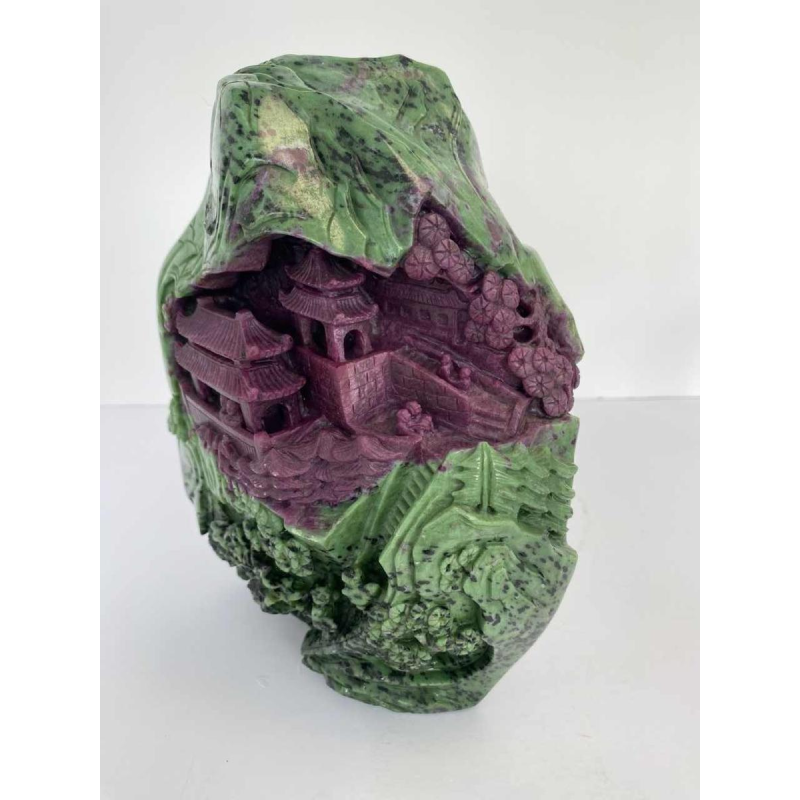 Rock carved from zoisite ruby depicting a lively Asian landscape