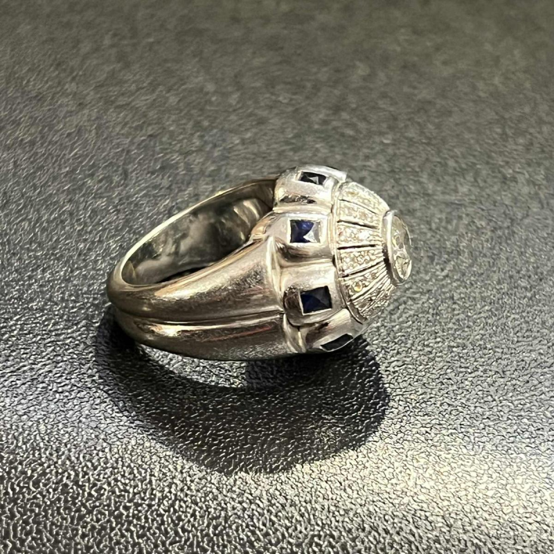 18K white gold ring set with a central diamond surrounded by smaller diamonds and sapphires