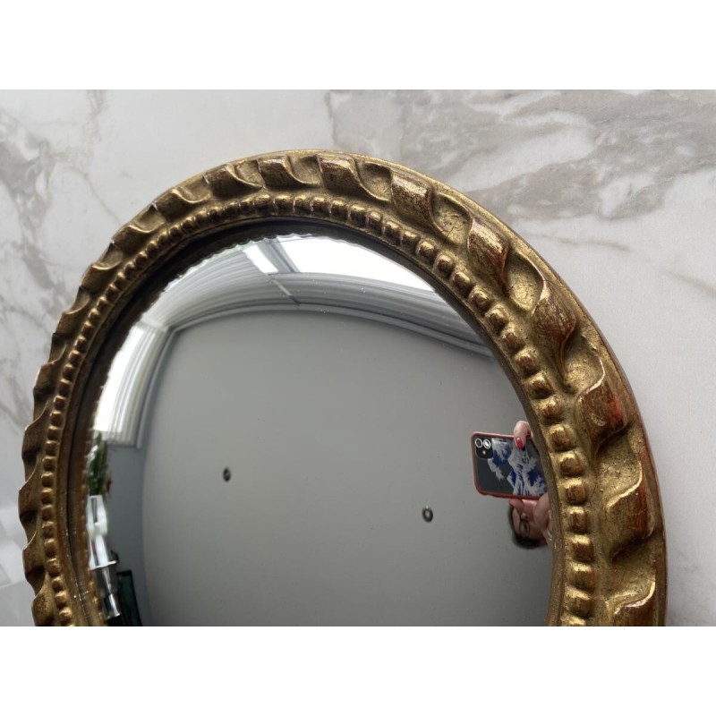 Circular "witch's eye" mirror in gilded carved wood