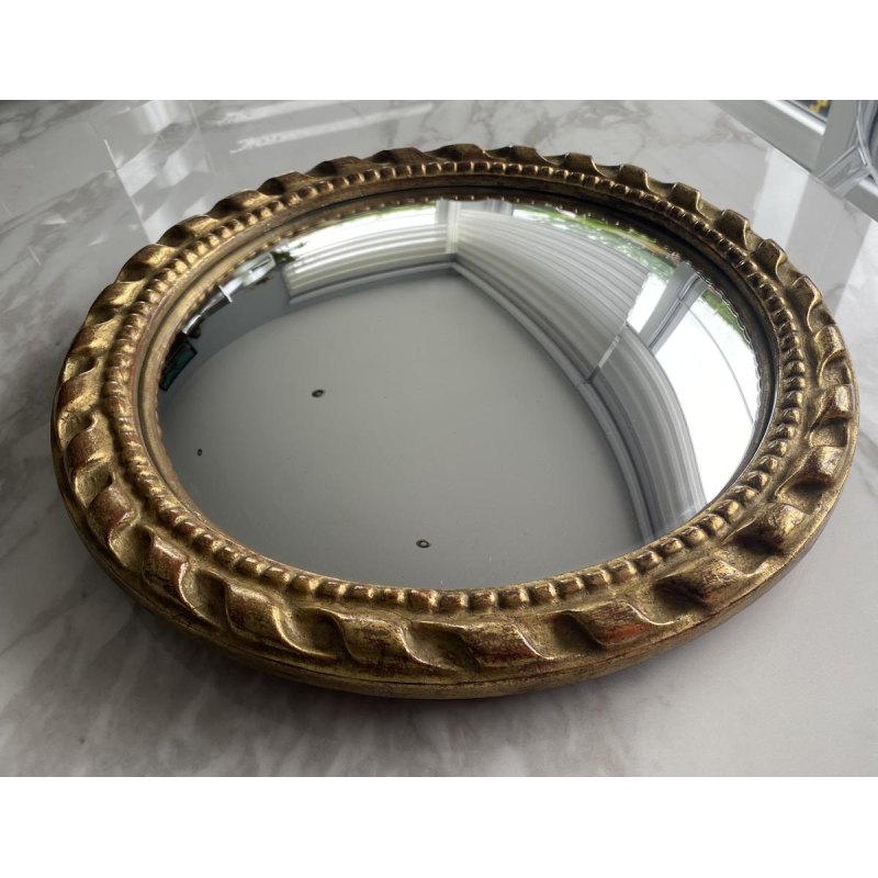 Circular "witch's eye" mirror in gilded carved wood