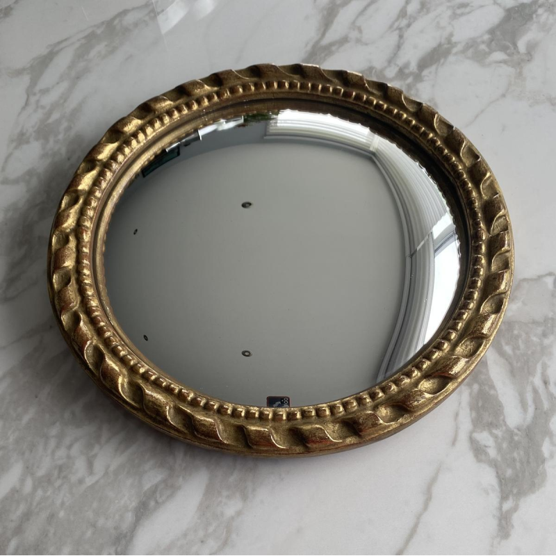 Circular "witch's eye" mirror in gilded carved wood