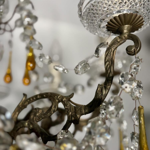 Achtarmige kroonluchter met hangers, in brons en kristal, met druppels van amberkleurig glas, circa 1900.