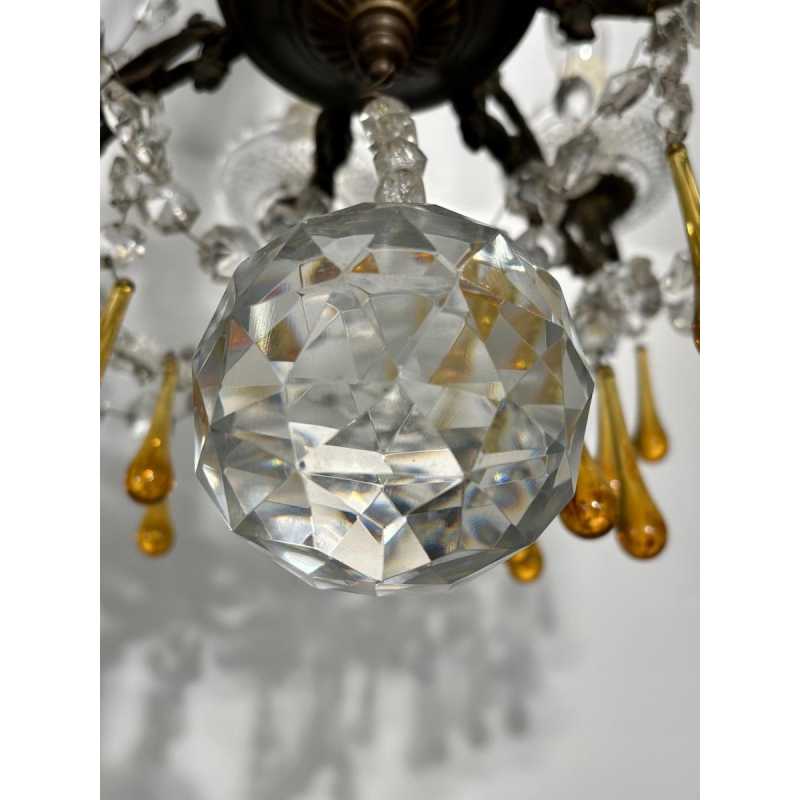Achtarmige kroonluchter met hangers, in brons en kristal, met druppels van amberkleurig glas, circa 1900.