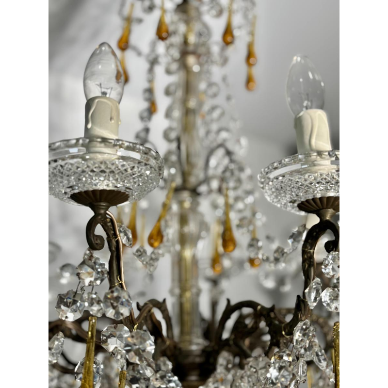 Achtarmige kroonluchter met hangers, in brons en kristal, met druppels van amberkleurig glas, circa 1900.