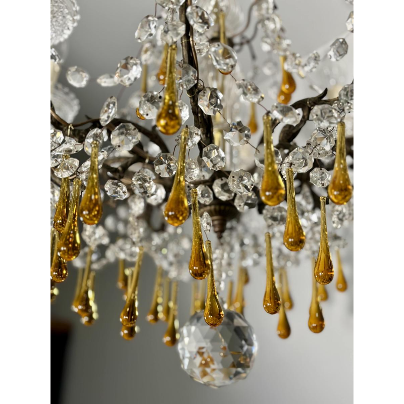 Achtarmige kroonluchter met hangers, in brons en kristal, met druppels van amberkleurig glas, circa 1900.