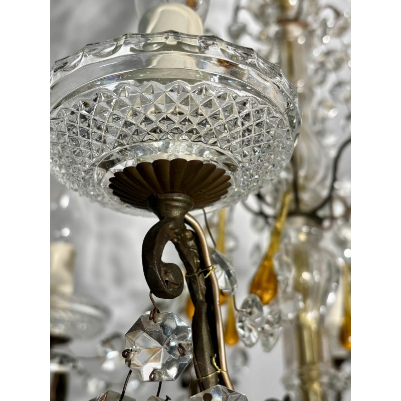 Achtarmige kroonluchter met hangers, in brons en kristal, met druppels van amberkleurig glas, circa 1900.