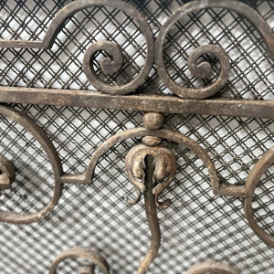 Grille en fer forgé martelé, motifs à décor de volutes, fleurs et feuillages, XXe s
