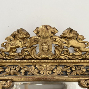 Louis XIV style closed-panel mirror in wood and gilt stucco, pediment with escutcheon and lions, 19th century