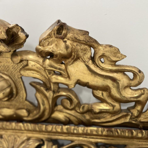 Louis XIV style closed-panel mirror in wood and gilt stucco, pediment with escutcheon and lions, 19th century