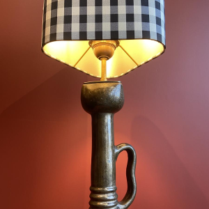 Bronzen tafellamp met een zwart-wit geblokte zijden lampenkap.