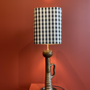 Bronzen tafellamp met een zwart-wit geblokte zijden lampenkap.
