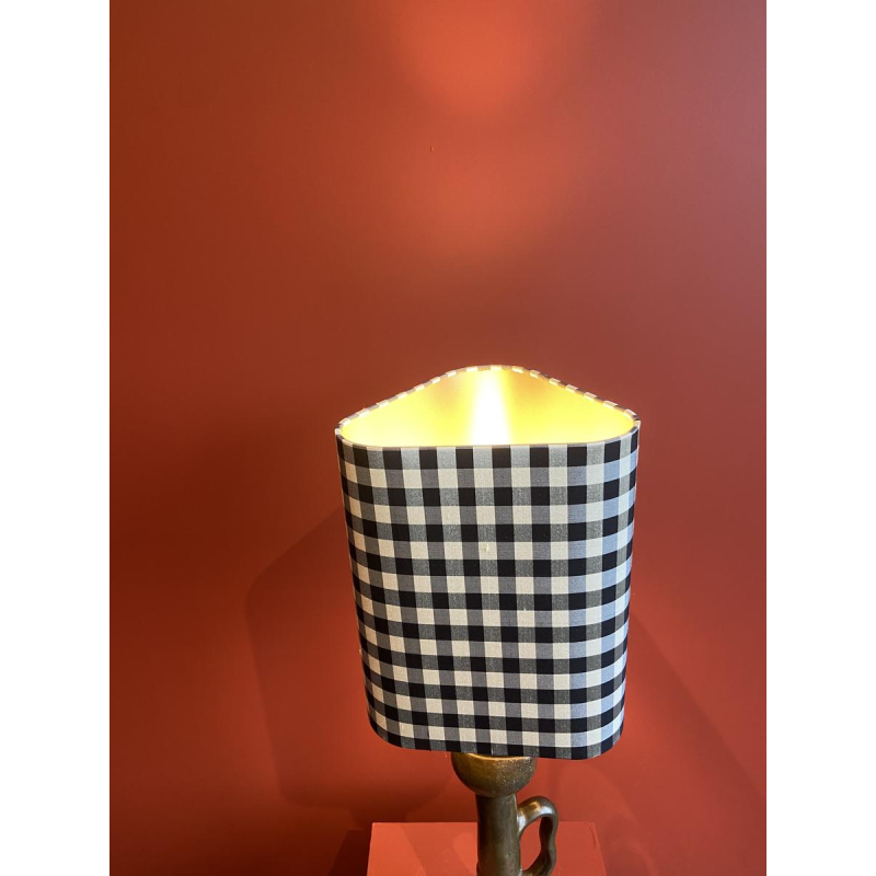 Bronzen tafellamp met een zwart-wit geblokte zijden lampenkap.