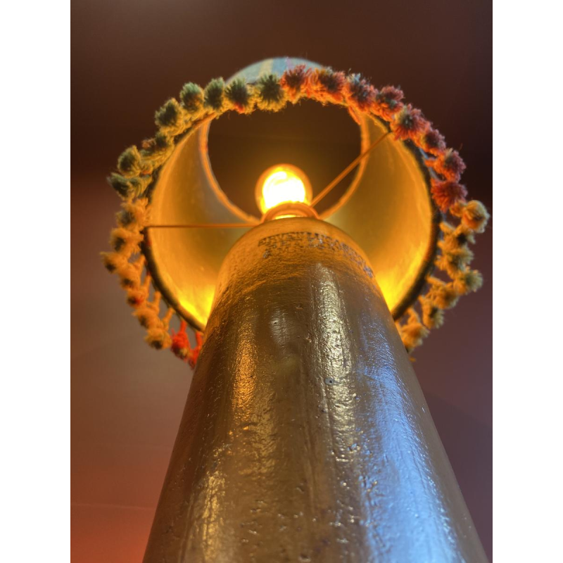 Lamp in de vorm van een "stenen fles" met een blauwe en veelkleurige lampenkap, handgeweven in India.