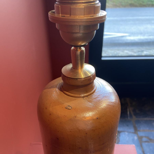 Lamp in de vorm van een "stenen fles" met een blauwe en veelkleurige lampenkap, handgeweven in India.