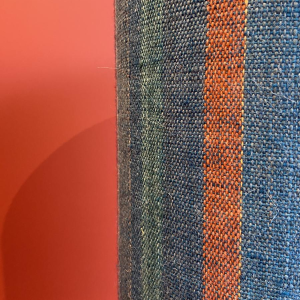 Lamp in de vorm van een "stenen fles" met een blauwe en veelkleurige lampenkap, handgeweven in India.