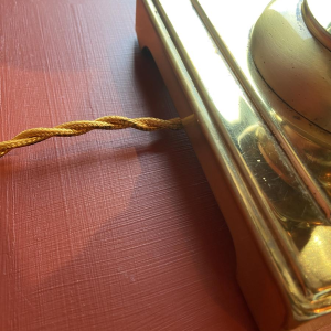 Verguld messing lampvoet, ovale lampenkap van bordeauxrode geruite zijde.