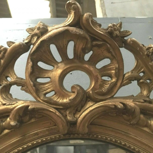 Louis XV oval mirror with pediment, wood and gilt stucco, beveled glass, Napoleon III