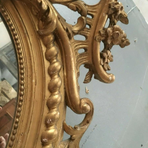 Louis XV oval mirror with pediment, wood and gilt stucco, beveled glass, Napoleon III