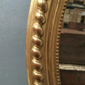 Louis XV oval mirror with pediment, wood and gilt stucco, beveled glass, Napoleon III