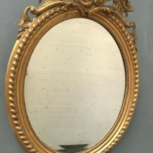 Miroir Louis VX ovale à fronton, bois et stuc doré, glace biseautée, Napoléon III