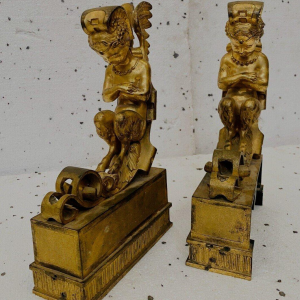 Een paar verguld bronzen haardijzers versierd met gevleugelde faunen, 19e eeuw.
