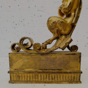 Een paar verguld bronzen haardijzers versierd met gevleugelde faunen, 19e eeuw.