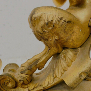 Een paar verguld bronzen haardijzers versierd met gevleugelde faunen, 19e eeuw.