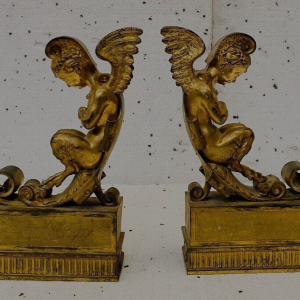 Een paar verguld bronzen haardijzers versierd met gevleugelde faunen, 19e eeuw.